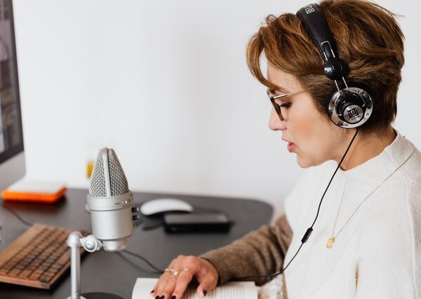 Lady recording a book using microphone and head set