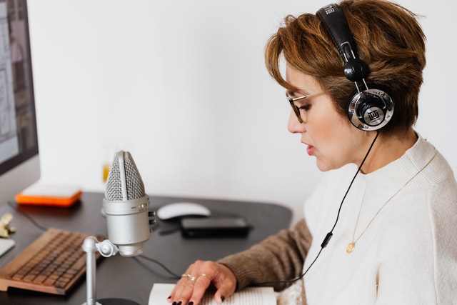 Lady recording a book using microphone and head set